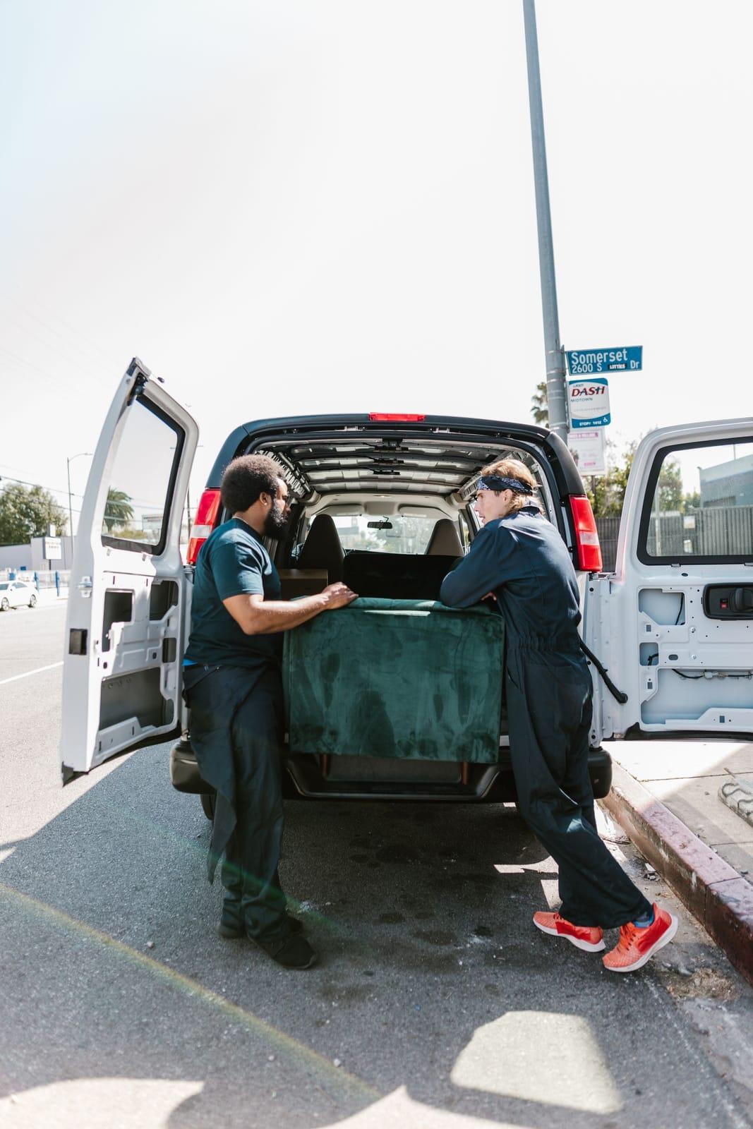 Uniformed crew loading unwanted items into a work van